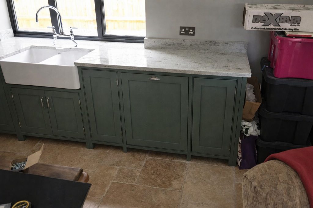 Handcrafted shaker-style kitchen units in Farrow & Ball Green Smoke with integrated legs, quartz worktops, and farmhouse sink in Chorleywood