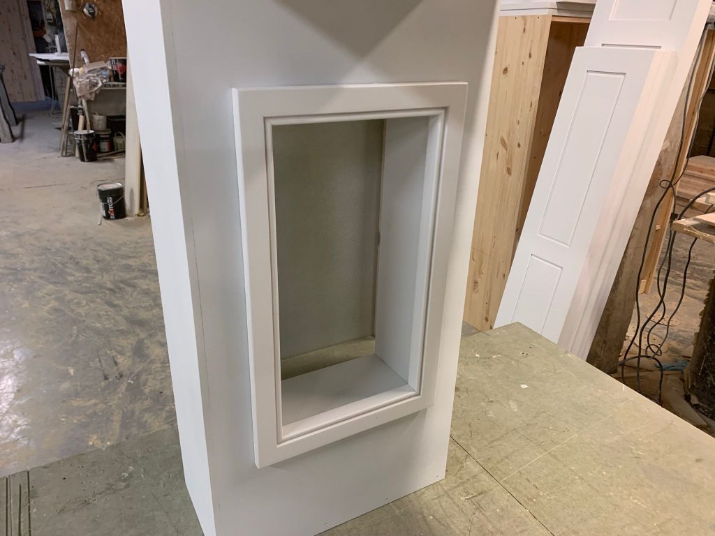 Left-hand cupboard within a bespoke kitchen overmantel, handcrafted in the workshop with recessed shaker-style detailing.