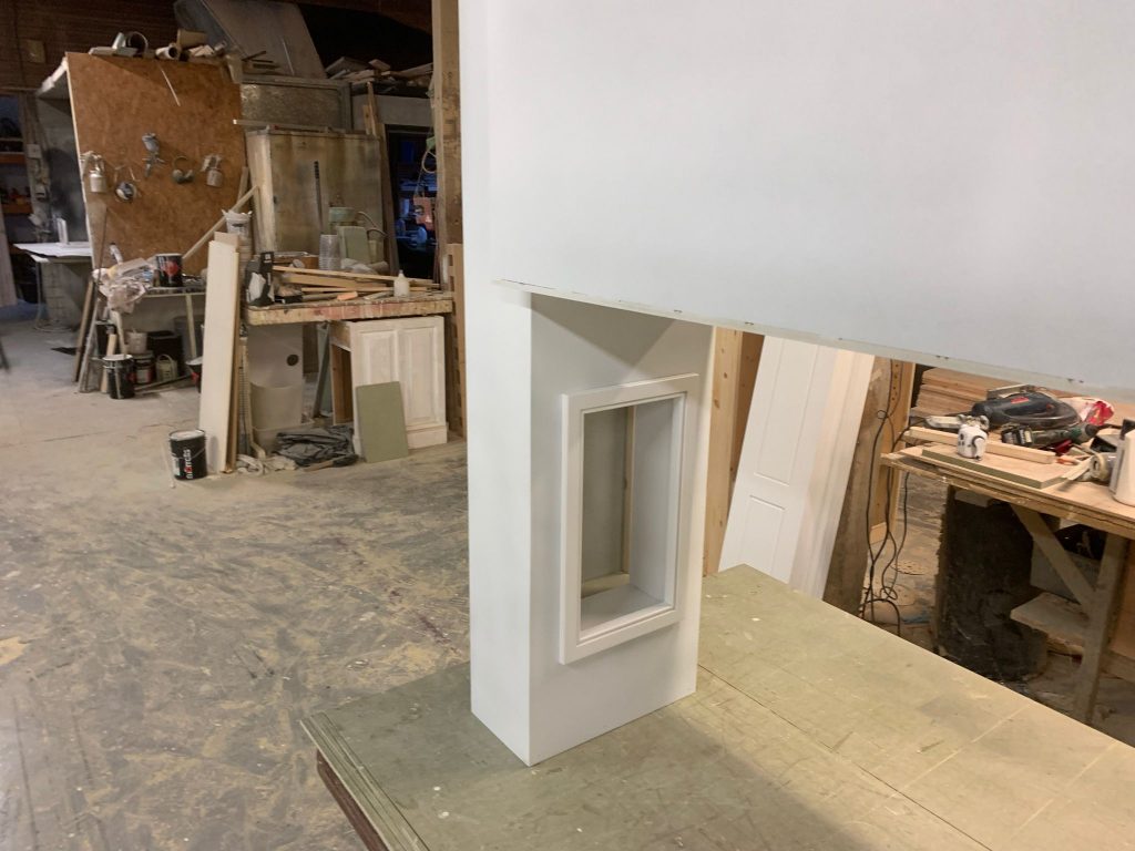 Left-hand overmantel side in workshop manufacture, showing precision joinery and recessed detailing.