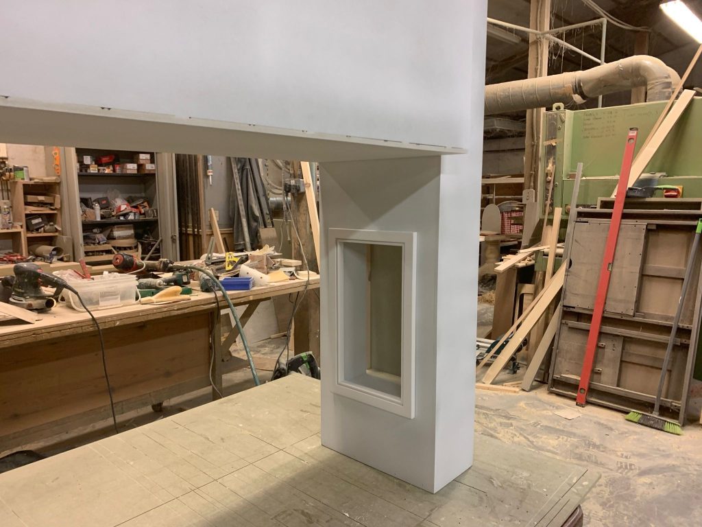 Right-hand side of a bespoke kitchen overmantel in workshop manufacture, showing precision joinery and recessed detailing.