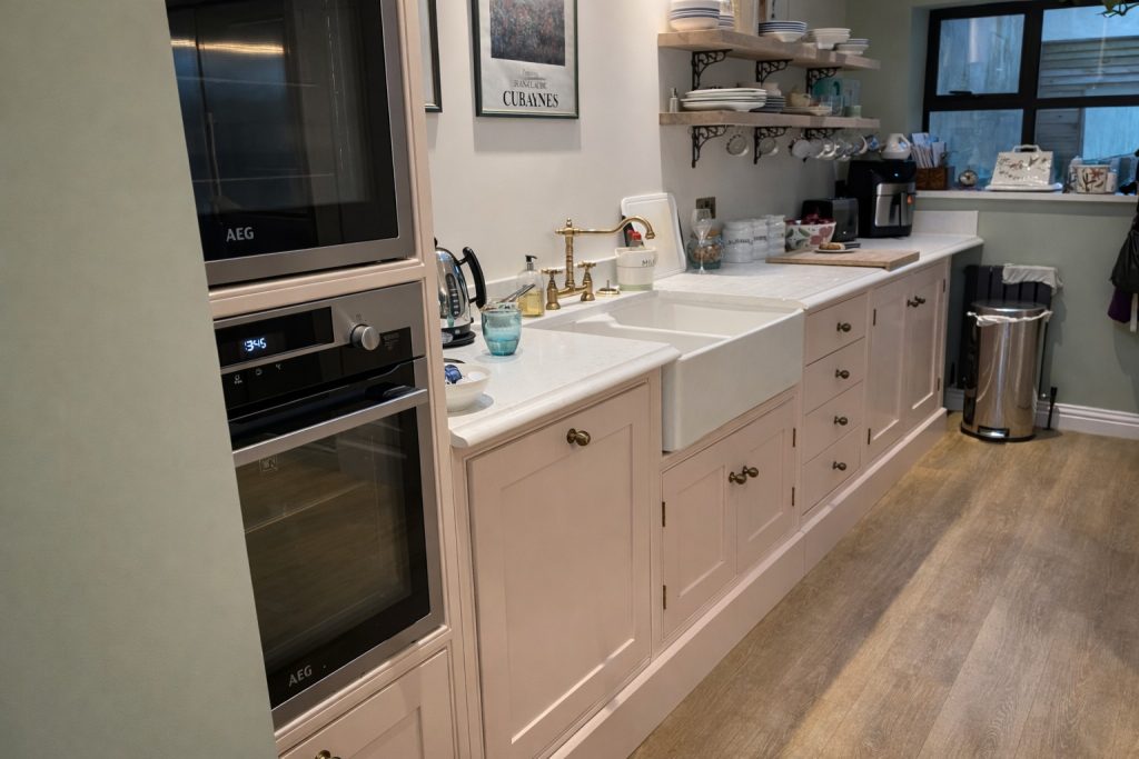 Bespoke shaker-style kitchen appliance wall with built-in ovens painted in Farrow & Ball Setting Plaster