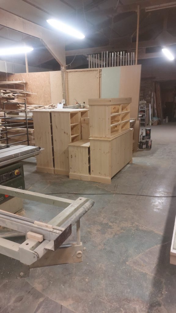 Pine furniture carcasses grouped together in the joinery workshop awaiting finishing