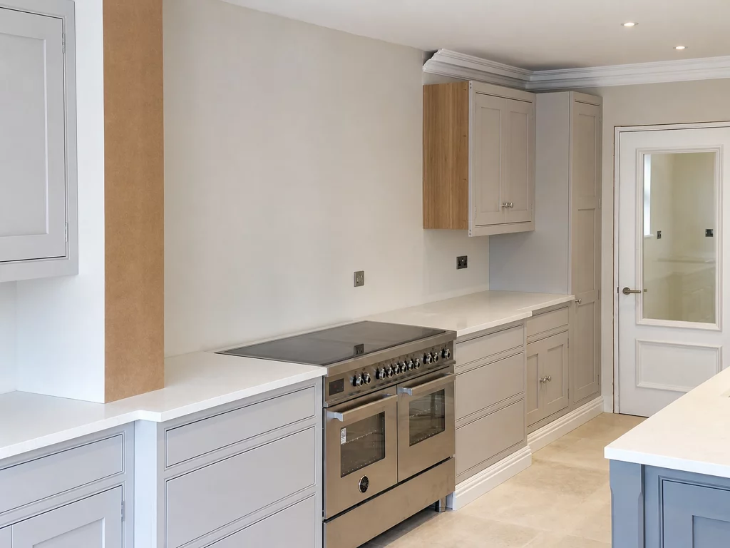 Grey in-frame kitchen installation with oak interiors and white quartz worktops in Braintree, range-cooker run and quartz worktop during installation.