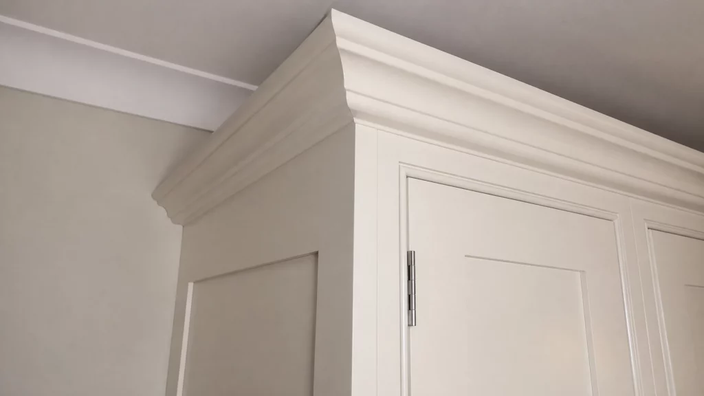 Dimpse-painted Shaker kitchen with a large granite island and integrated appliances, moulded cornice and painted tall-cabinet detail.