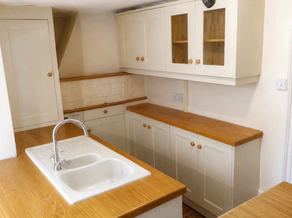 Compact painted Shaker kitchen with solid oak worktops in Little Waltham, oak-topped base cabinets on the return wall.