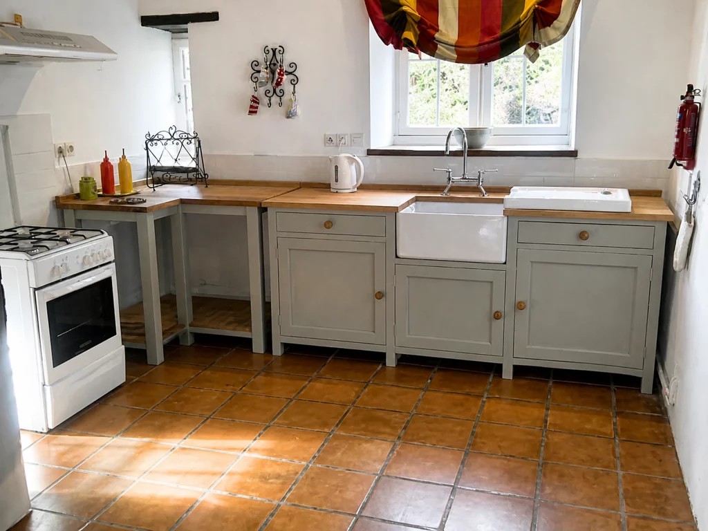 Compact painted Shaker kitchen with solid oak worktops in Little Waltham, wide view of the sink wall and freestanding cooker.
