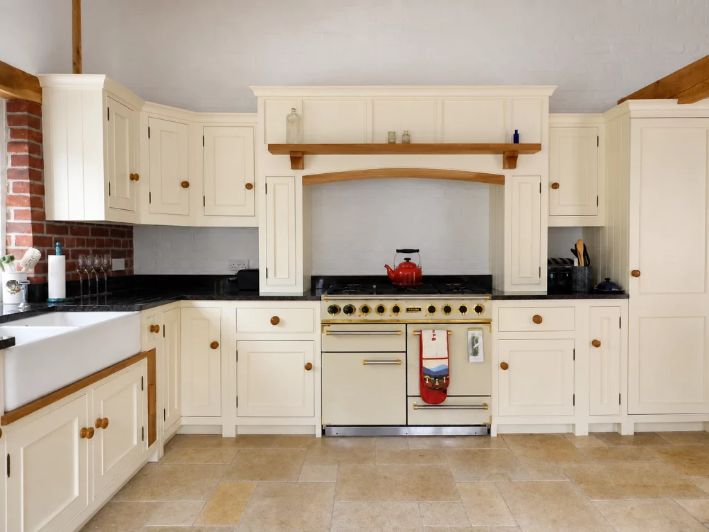 Painted country Shaker kitchen with dark stone worktops and a range-cooker surround, front view of the range cooker and bespoke overmantel.
