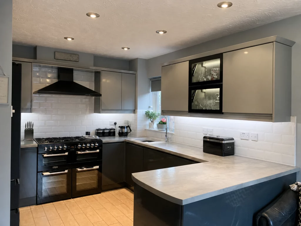 Contemporary two-tone kitchen with a curved peninsula and stone-effect worktop, cooking wall and peninsula viewed from the living area.