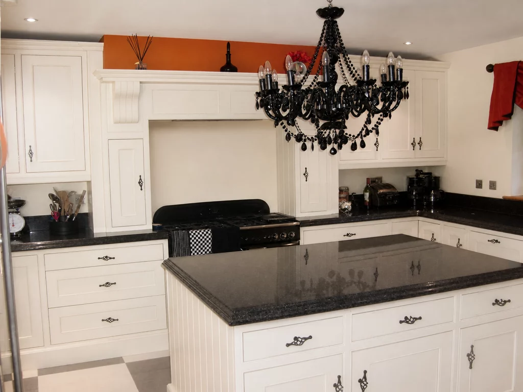 White painted Shaker kitchen with Star Galaxy granite and a central island in Wickham Bishops, island foreground with the range wall beyond.