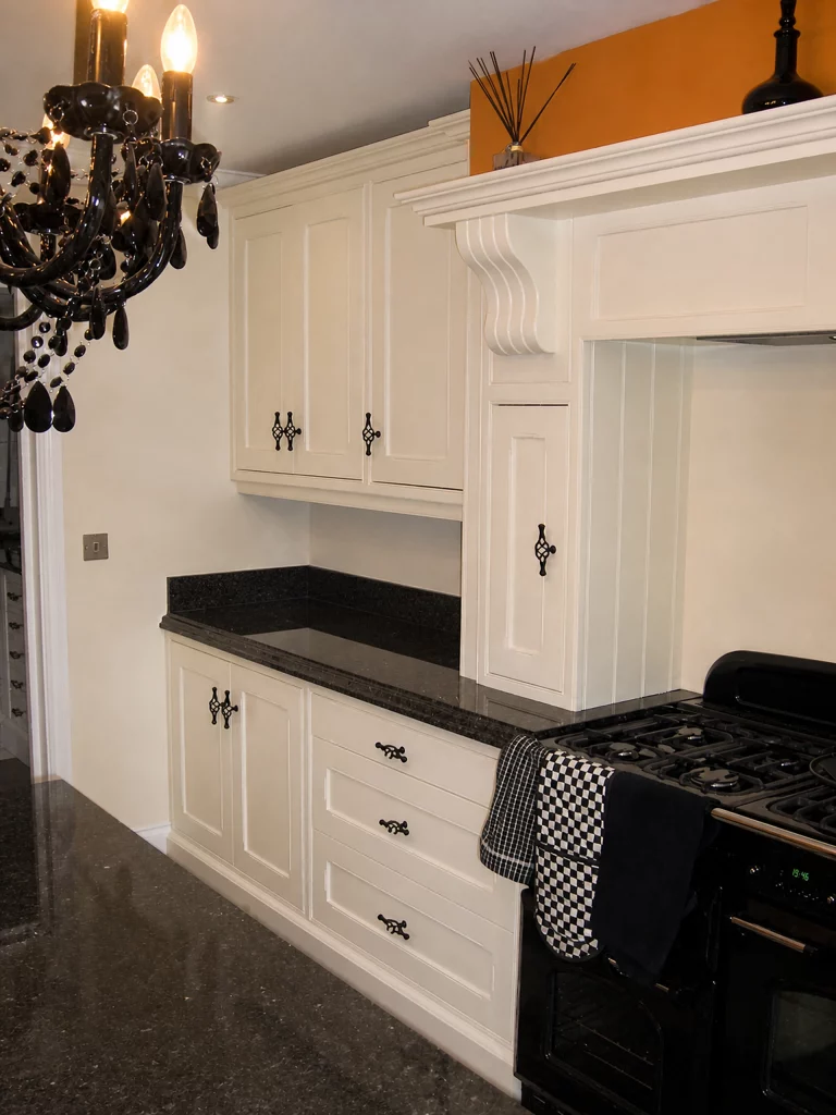 White painted Shaker kitchen with Star Galaxy granite and a central island in Wickham Bishops, range wall with detailed painted overmantel.