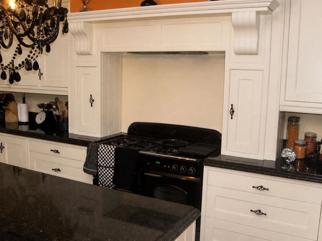 White painted Shaker kitchen with Star Galaxy granite and a central island in Wickham Bishops, close view of the range-cooker overmantel.